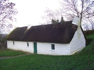 Thatched roof cottage white wash exterior in a rural setting