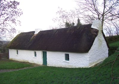Thatched roof cottage white wash exterior in a rural setting