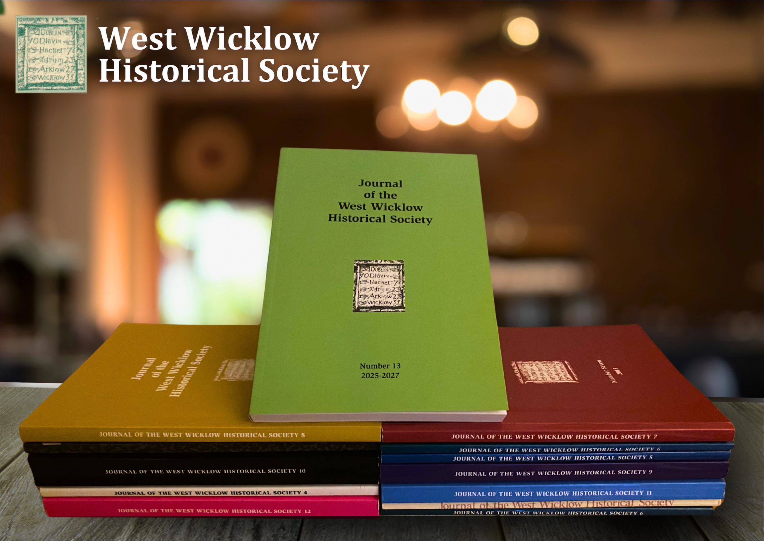 Journal 13 from West Wicklow Historical Society on top of stacked colourful journals